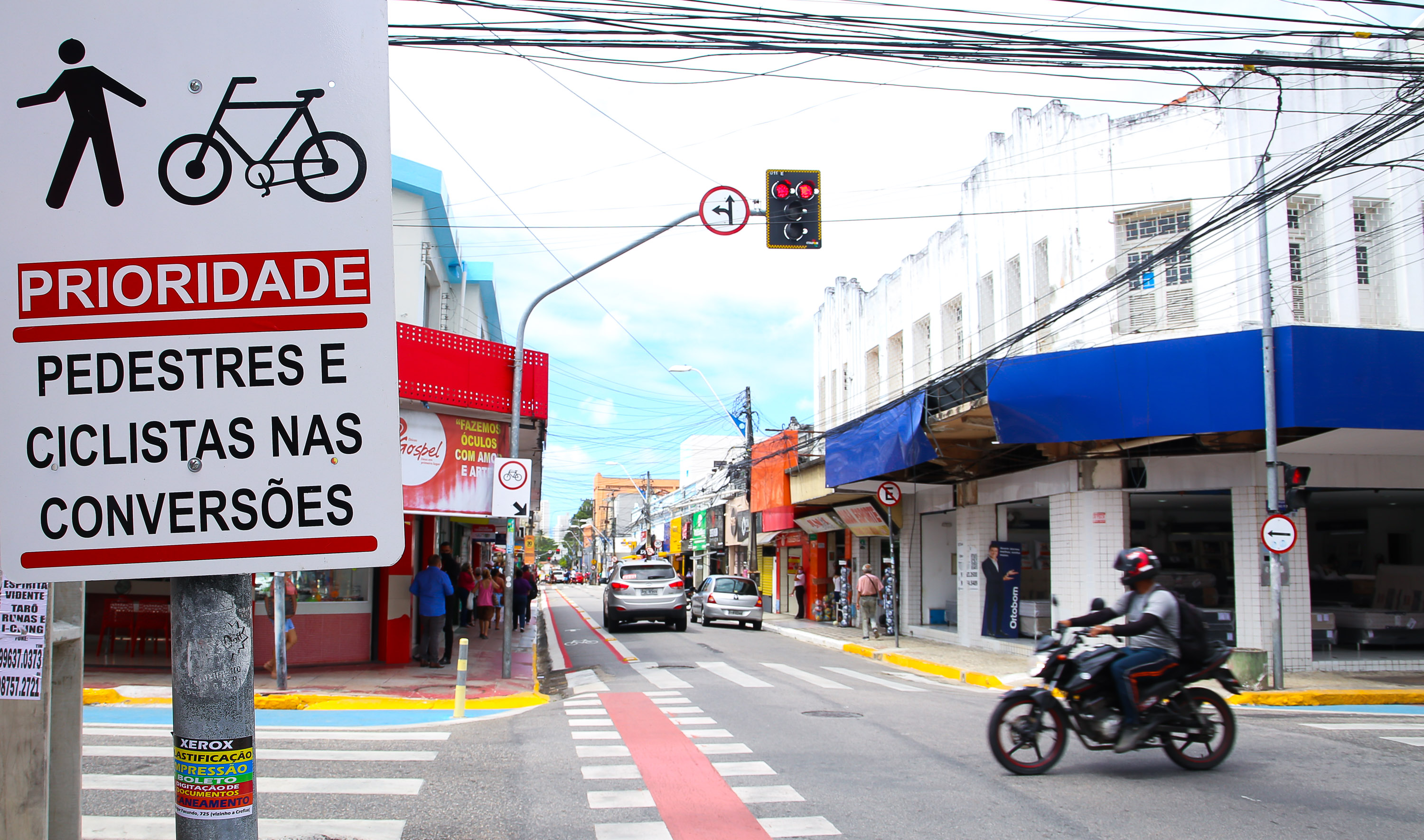 a foto mostra um cruzamento de rua em Fortaleza com semáforo e sinalização horizontal
